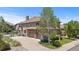Exterior of the home with stone accents, a tile roof, and a three-car garage at 14325 N Santa Fe St, Broomfield, CO 80023