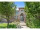 Charming front entrance featuring stone accents, an arched doorway, and lush landscaping at 14325 N Santa Fe St, Broomfield, CO 80023