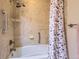 Bathroom with tiled shower/tub combo featuring grab bars and modern fixtures at 7573 S Saulsbury Ct, Littleton, CO 80128