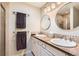 Bathroom featuring double sinks, framed mirrors, granite countertops, and modern fixtures at 7573 S Saulsbury Ct, Littleton, CO 80128