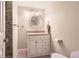 Bathroom featuring a single sink vanity with a granite countertop and a round mirror at 7573 S Saulsbury Ct, Littleton, CO 80128