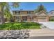 Inviting two-story home with a well-manicured lawn, mature trees, and a brick facade at 7573 S Saulsbury Ct, Littleton, CO 80128