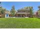 Back of home featuring a large grass yard and covered porch with seating and dining areas at 7573 S Saulsbury Ct, Littleton, CO 80128