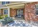 Inviting covered front porch with brick detail and decorative plants at 7573 S Saulsbury Ct, Littleton, CO 80128