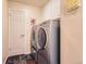 Bright laundry room featuring a modern washer and dryer, white cabinets, and slate tile floors at 7573 S Saulsbury Ct, Littleton, CO 80128