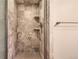 Tiled shower with shelves and chrome shower head and handle at 7573 S Saulsbury Ct, Littleton, CO 80128