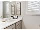 Bathroom showcasing an ample vanity with framed mirror and a window with privacy shutters at 2578 Palau Way, Castle Rock, CO 80109
