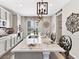 The gourmet kitchen features a large island with bar seating, modern lighting, and updated appliances at 2578 Palau Way, Castle Rock, CO 80109