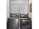 A laundry room featuring front loading washer/dryer and gray cabinets above at 2578 Palau Way, Castle Rock, CO 80109