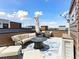 Rooftop deck with outdoor sectional, firepit, chairs and an umbrella for shade at 2578 Palau Way, Castle Rock, CO 80109