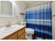 This is a bathroom featuring a wooden cabinet and a blue and white striped shower curtain at 2529 S Truckee Way, Aurora, CO 80013