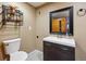This bathroom features a toilet, sink, faucet, and mirror with light brown walls at 2529 S Truckee Way, Aurora, CO 80013