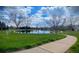 Picturesque pond with surrounding walking path and mature trees providing a serene community amenity at 2529 S Truckee Way, Aurora, CO 80013