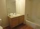 Bright bathroom features a combination tub/shower and vanity with wood cabinets at 555 Alton Way # E, Denver, CO 80230