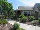 Charming home exterior with a welcoming walkway, mature trees, and colorful flower beds at 555 Alton Way # E, Denver, CO 80230