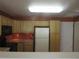 Functional kitchen with light wood cabinetry, appliances, and laminate countertops offering plenty of space at 555 Alton Way # E, Denver, CO 80230