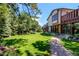 Large backyard with lush green grass, mature trees, and a stone paver walkway at 559 E 2Nd Ave, Castle Rock, CO 80108
