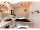 Bright bathroom features a soaking tub, chandelier, and modern fixtures at 559 E 2Nd Ave, Castle Rock, CO 80108