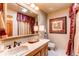 Bright bathroom with a large mirror, wooden cabinets, and tile flooring at 559 E 2Nd Ave, Castle Rock, CO 80108