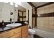Neutral toned bathroom featuring a bathtub, vanity with a black countertop and decorative mirror at 943 S Zeno Way # 207, Aurora, CO 80017