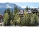 Exterior of a condo with trees and a mountain in the background on a bright and sunny day at 655 Four O Clock Rd # 104, Breckenridge, CO 80424