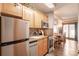 Open kitchen with stainless steel refrigerator, light wood cabinets, and view into the dining area and sliding glass doors at 655 Four O Clock Rd # 104, Breckenridge, CO 80424