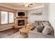 Comfortable living room featuring stone fireplace, wood floors and a large window with blinds at 655 Four O Clock Rd # 104, Breckenridge, CO 80424