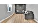 Finished basement with wood-look floors and gray couches at 13464 E 107Th Ave, Commerce City, CO 80022