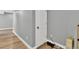 A basement area featuring a gray wall, white door, and wooden floor, perfect for additional living space at 13464 E 107Th Ave, Commerce City, CO 80022