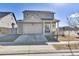 Charming two-story home with a two-car garage and a cozy front porch featuring a table and chairs at 13464 E 107Th Ave, Commerce City, CO 80022