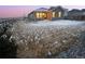 Backyard with brown siding home, snowy patches, and a gravel area at dusk at 27699 E 7Th Ln, Aurora, CO 80018