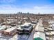 Aerial view featuring a modern house with a cityscape backdrop, nestled in a snow-covered neighborhood at 1864 W 41St Ave, Denver, CO 80211