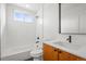 A stylish bathroom features a shower-tub combo and a modern vanity at 1864 W 41St Ave, Denver, CO 80211