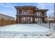 Modern two-story home featuring brick facade, balconies, and large windows, set against a snowy front yard at 1864 W 41St Ave, Denver, CO 80211