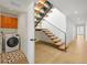 Hallway with modern floating stairs and a conveniently located laundry room with patterned tile flooring at 1864 W 41St Ave, Denver, CO 80211