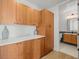 Hallway with wood cabinets and a glimpse into a well-lit bathroom with sleek fixtures at 1864 W 41St Ave, Denver, CO 80211