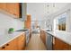 Stylish kitchen featuring wood cabinets, stainless steel appliances, subway tile backsplash, and an island sink at 1864 W 41St Ave, Denver, CO 80211