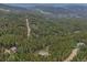 An aerial view shows the trees and mountains surrounding the house and neighborhood at 509 Paiute Rd, Evergreen, CO 80439