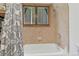 Bright bathroom featuring a bathtub with white tiling and a shower with a view of trees at 509 Paiute Rd, Evergreen, CO 80439