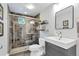 Bathroom with tiled shower, gray vanity, toilet, and decorative shelf and mirror at 509 Paiute Rd, Evergreen, CO 80439