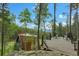 An exterior shot shows a wood deck and chairs overlooking the trees and mountains in the distance at 509 Paiute Rd, Evergreen, CO 80439