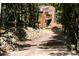 Stunning exterior of a modern home with a balcony, complemented by a stone retaining wall and lush trees at 509 Paiute Rd, Evergreen, CO 80439