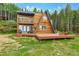 Charming A-frame home with a spacious wooden deck and lush greenery at 509 Paiute Rd, Evergreen, CO 80439
