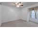 This bedroom features neutral carpet, a ceiling fan, and a sunlit window at 2019 S Hannibal St # C, Aurora, CO 80013