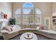 Comfortable living room with a large sectional sofa, rounded ottoman, and large windows offering natural light at 20790 Bridlewood Ln, Parker, CO 80138