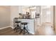 Well-lit kitchen with stainless steel appliances, breakfast bar with seating and wood-look floors at 8264 S Fillmore Way, Centennial, CO 80122