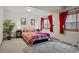 Basement bedroom with comfortable queen bed, red accents, and plenty of space at 7172 Waterford Ct, Niwot, CO 80503