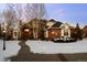 Brick two-story home with a snow-covered front yard and walkway at 7172 Waterford Ct, Niwot, CO 80503