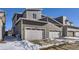 Gray townhome exterior with attached two-car garage and snowy driveway at 9643 Truckee St, Commerce City, CO 80022