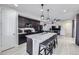 Modern kitchen with dark cabinetry, granite counters, and island at 9643 Truckee St, Commerce City, CO 80022